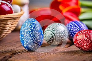 Easter eggs with tulips on weathered wooden background