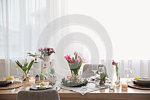 Beautiful Easter table setting with beautiful flowers in living room