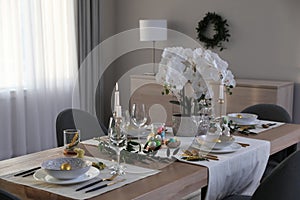 Beautiful Easter table setting with orchid flowers indoors