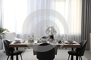 Beautiful Easter table setting with orchid flowers indoors