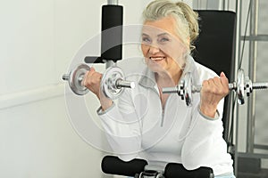 Beautiful elderly woman exercising in the gym