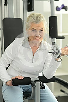 Beautiful elderly woman exercising in the gym