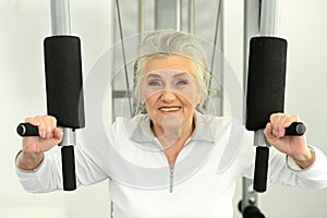 Beautiful elderly woman exercising in the gym