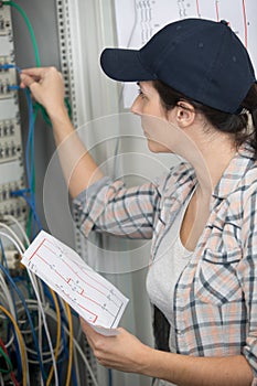 beautiful electrician inspecting fuseboard