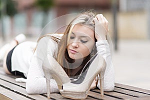 Beautiful elegance young woman lying on bench with heels.