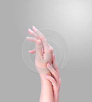 Beautiful and elegant adult woman empty hands side isolated on gradient gray background, concept of applying moisturizing cream,