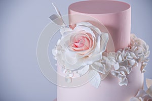 Beautiful elegant four tiered pink wedding cake decorated with roses flowers. Concept floral from sugar mastic