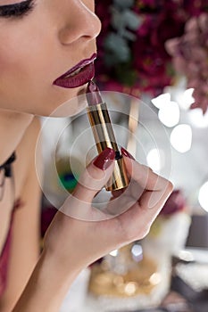 Beautiful elegant girl with bright makeup lipstick lipstick color Marsala in front of the mirror in the dressing room