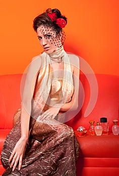 Beautiful elegant lady sitting on red sofa