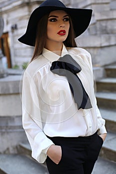 Beautiful elegant ladylike woman in blouse and felt hat