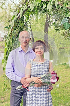 Beautiful elegant middle aged couple posing in a park.