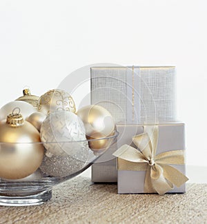 Beautiful, elegant silver and gold Christmas gifts and glass bowl with baubles ornaments. Fancy, luxury holiday home decor