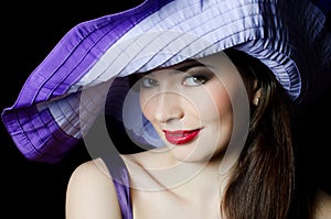 Beautiful elegant woman in a lilac hat