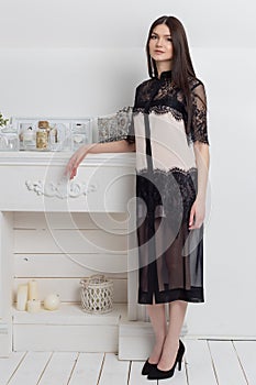 Beautiful elegant woman with long hair with a gentle make-up in the studio shows elegant white business dress