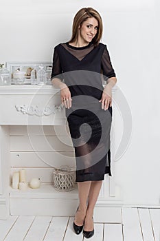 Beautiful elegant woman with long hair with a gentle make-up in the studio shows elegant white business dress