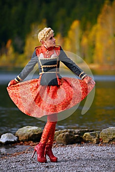 Beautiful elegant woman by mountain lake in autumn