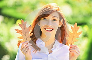 Beautiful elegant woman standing in a park in autumn. Beautiful girl walking outdoors in autumn. Smiling girl collects