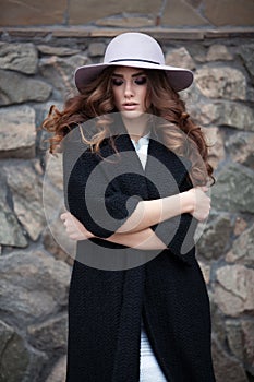 Beautiful elegant woman in stylish trendy black coat and hat ove