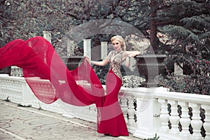 Beautiful elegant woman wearing in long mermaid fluttering fashion dress in winter park, outdoors full length portrait.