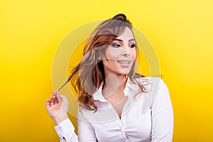 Beautiful elegant woman in white shirt on yellow background