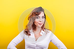 Beautiful elegant woman in white shirt on yellow background