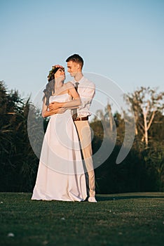 beautiful elegant young wedding couple embracing and smiling each other