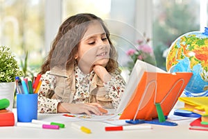 Beautiful emotional girl draws with colored pencils. At the table.