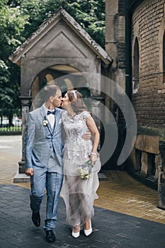 Beautiful emotional wedding couple kissing and walking in european city. Provence wedding. Stylish happy bride and groom walking