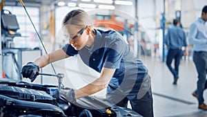 Beautiful Empowering Female Mechanic is Working on a Car in a Car Service. Woman in Safety Glasses