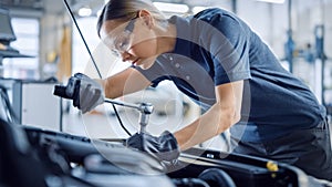 Beautiful Empowering Female Mechanic is Working on a Car in a Car Service. Woman in Safety Glasses