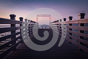 Beautiful empty wooden footbridge pier in koper in colorful purple sunset, slovenia