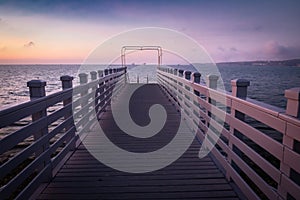 Beautiful empty wooden footbridge pier in koper in colorful purple sunset, slovenia