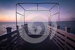 Beautiful empty wooden footbridge pier in koper in colorful purple sunset, slovenia