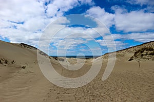 Beautiful endless sand dunes on the baltic sea coast under bright blue sky with clouds, Curonian Spit, Lithuania