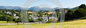 Beautiful English country village of Hawkshead Lake District Cumbria UK in summer with blue sky church panorama