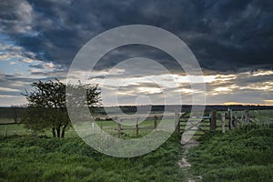 Beautiful English countryside landscape over fields at sunset