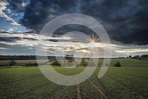 Beautiful English countryside landscape over fields at sunset