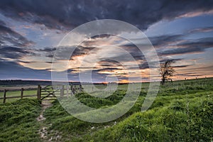 Beautiful English countryside landscape over fields at sunset