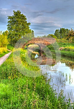 Beautiful English river and bridge on calm still day in colourful HDR