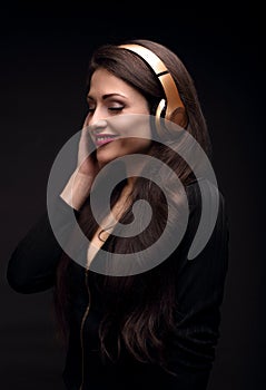 Beautiful enjoying long hair young woman listening the music in