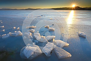 Beautiful epic ice crystal in the frozen bay. Sun rays reflection