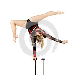 Beautiful equilibrist in a red and black suit, performs exercises on acrobatic canes