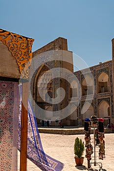 Beautiful ethnic fabrics waving with the wind next to ancient madrasah, Bukhara