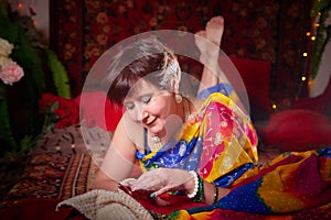 A beautiful European girl with short hair looking like an Arab woman in a red room in a harem. Photo shoot of an