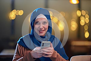 A beautiful European Muslim woman, adorned with a hijab, utilizes her smartphone to swiftly prepare for iftar during the