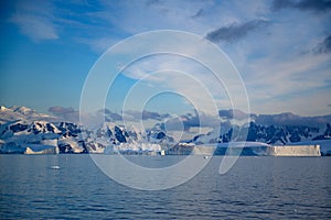 Antarctic landscape with snowcapped mountains, icebergs and glacier near Andvor Bay, Antactic Peninsular photo