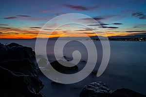 Beautiful evening photo of Lac Leman close to Lausanne, with sun just behind the horizon and long exposure of water