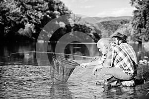 Beautiful evening riverside. Men at riverside catching fish. Friends spend nice time at riverside. Experienced fisherman