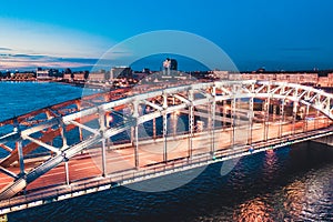 Beautiful evening scene with the famous Tower Bridge of St.Petersburg illuminated and reflected in Neva river photo