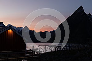 Beautiful evening sky over the mountains of Lofoten, Norway with a fishermen\'s hut and a fishing rack in front